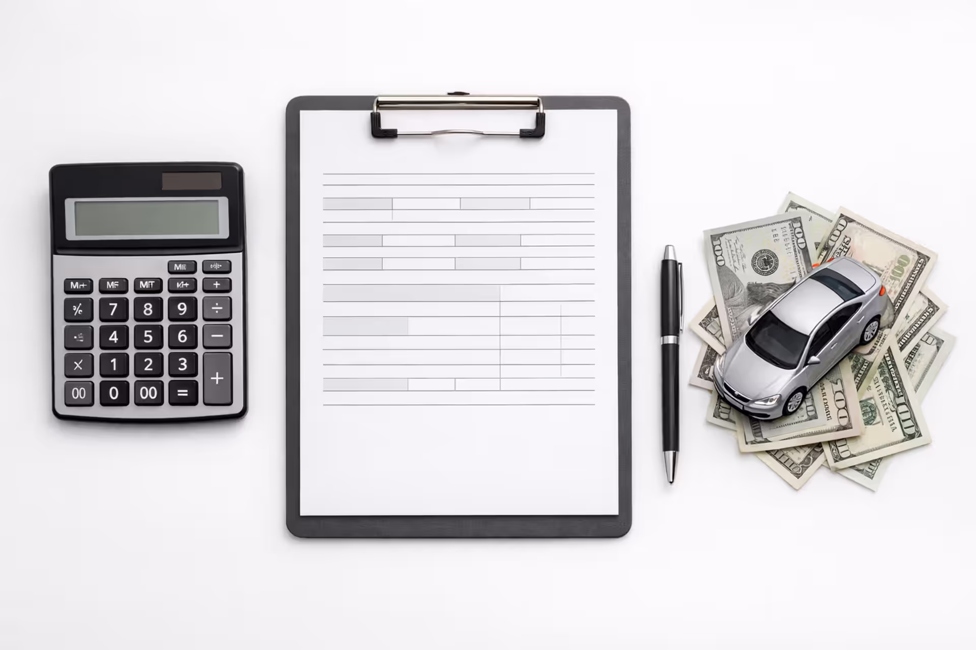 Calculator, car loan document, pen, toy car, and US dollar bills on a desk representing car payment calculation
